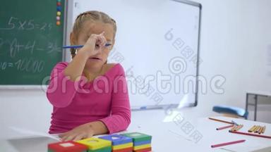 <strong>开学</strong>那天，女学生在教室的<strong>课</strong>桌上用黑板背景的文案写作业